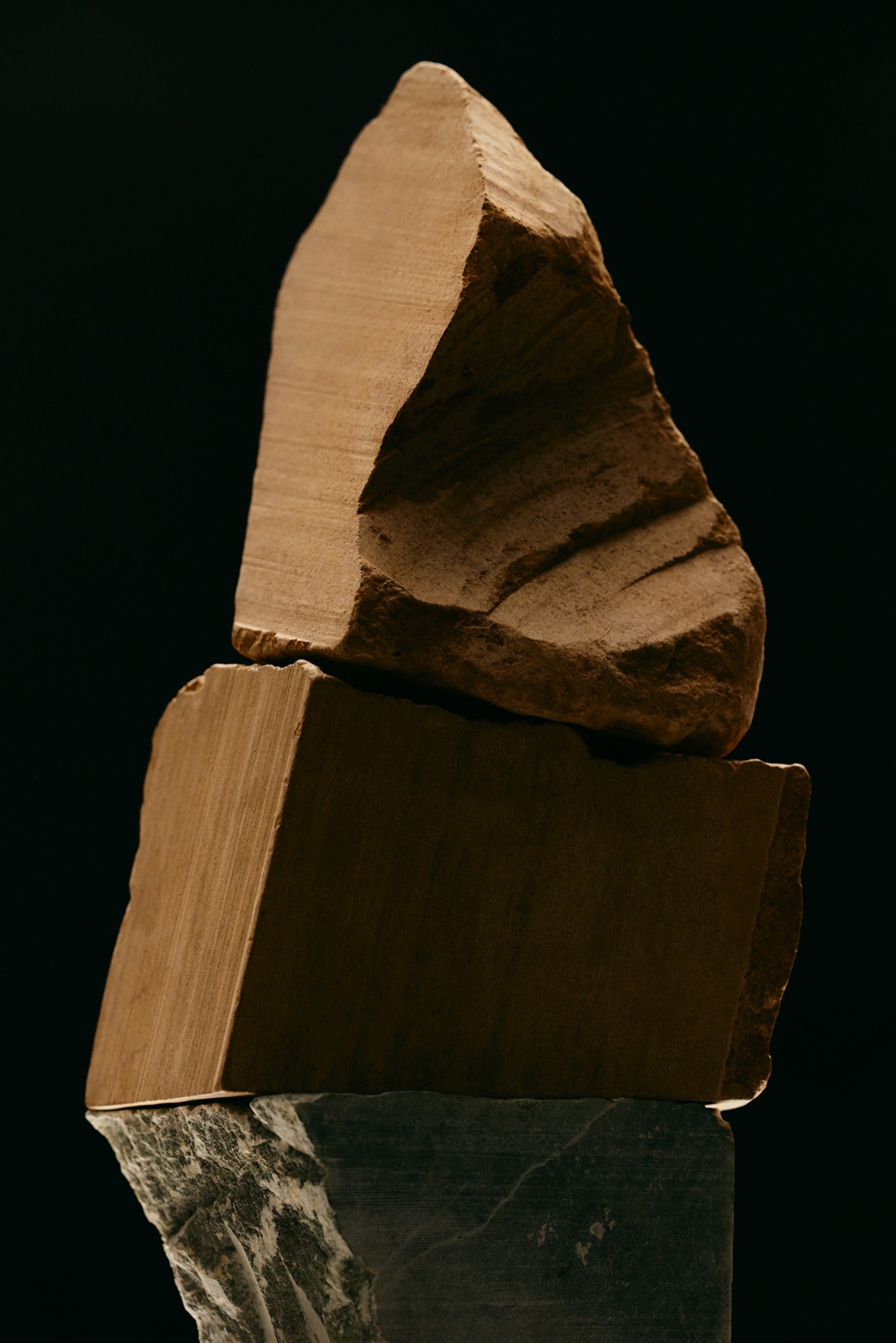 A sandstone keystone resting at the apex of an arch — the load-bearing stone the structure depends on.