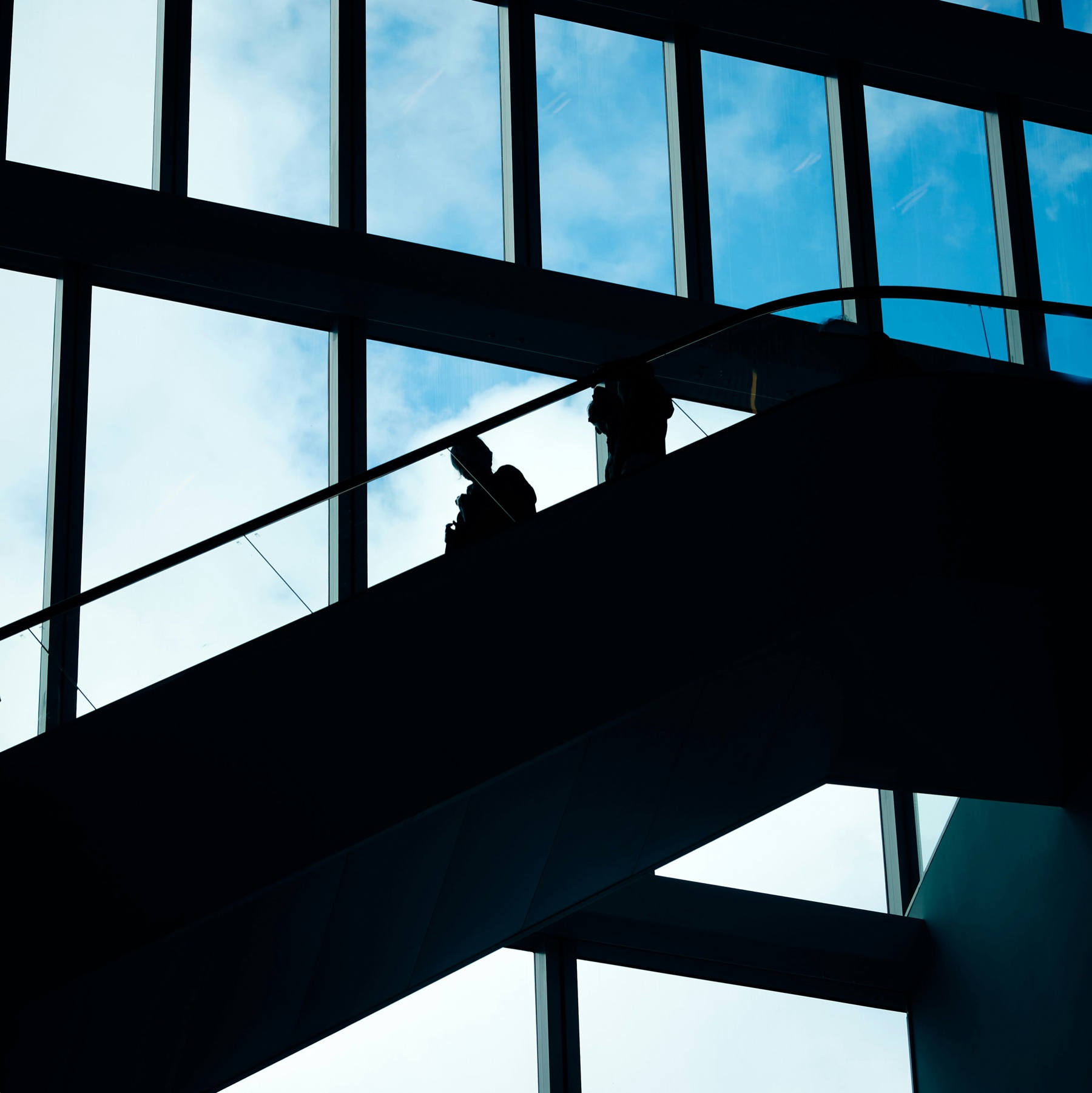 A modern stairwell ascending toward a skylight.